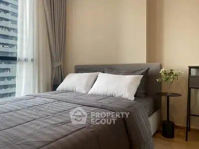 Modern bedroom with elegant decor and city view from large window.