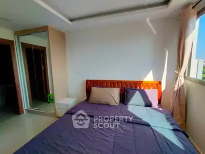 Spacious bedroom with large window and modern furnishings