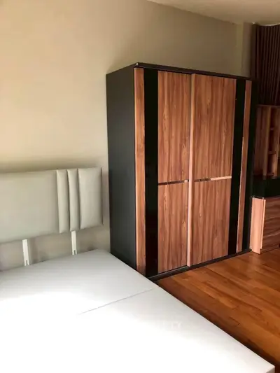 Modern bedroom with sleek wooden wardrobe and minimalist bed design
