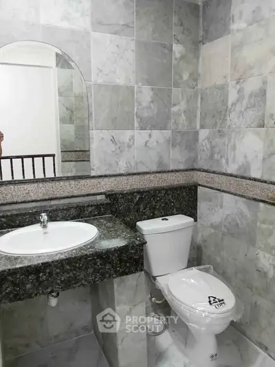 Elegant bathroom with marble tiles and modern fixtures in a luxury apartment.