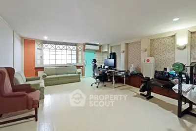 Spacious living room with home office setup and exercise equipment, ideal for versatile living.