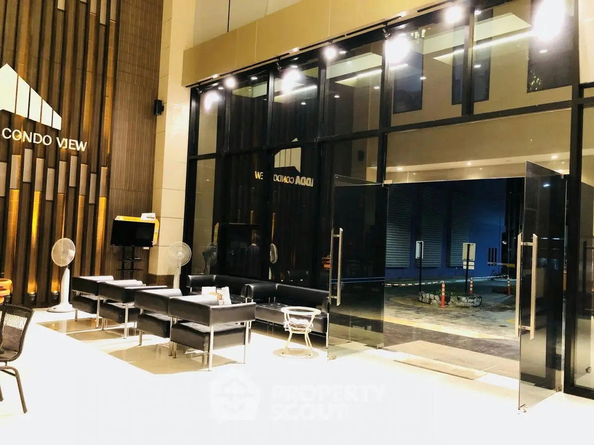 Modern condo entrance with sleek glass doors and stylish seating area