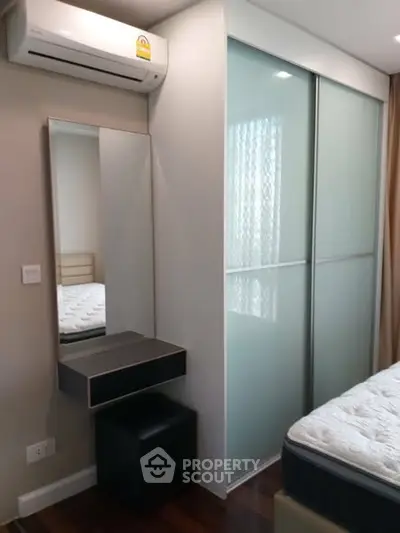 Modern bedroom with sleek sliding closet doors and wall-mounted mirror