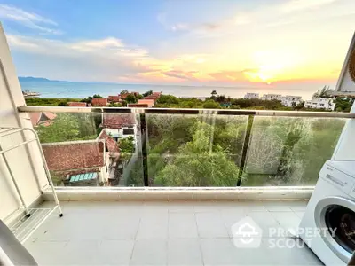 Stunning balcony view with ocean sunset and lush greenery, perfect for relaxation and enjoying nature.