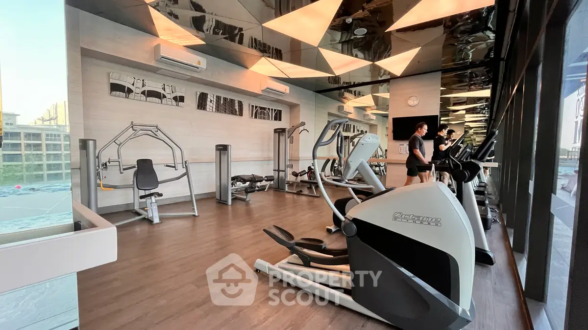Modern gym with state-of-the-art equipment and mirrored walls in a luxury residential building.