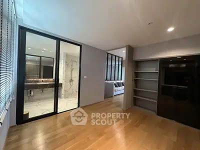 Spacious modern bedroom with ensuite bathroom and sleek wooden flooring.
