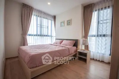 Cozy bedroom with large windows and modern decor in a stylish apartment.