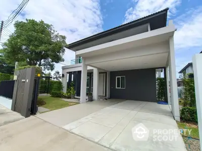 Modern two-story house with spacious driveway and lush greenery