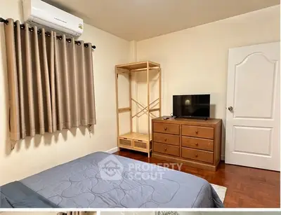 Cozy bedroom with air conditioning and wooden furniture, perfect for relaxation.