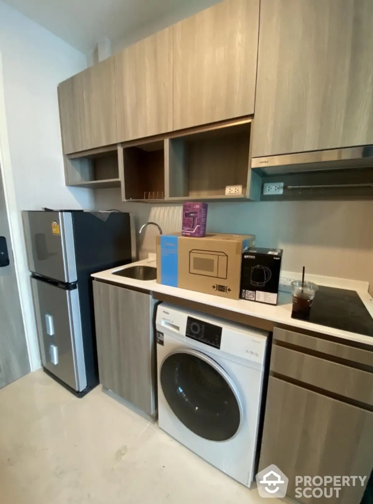 Modern kitchen with compact appliances and sleek wooden cabinetry