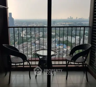 Stunning high-rise balcony with panoramic city view and cozy seating area.