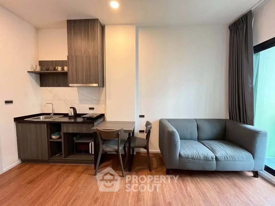 Modern open-layout kitchen and cozy living room with stylish furniture and wooden flooring.