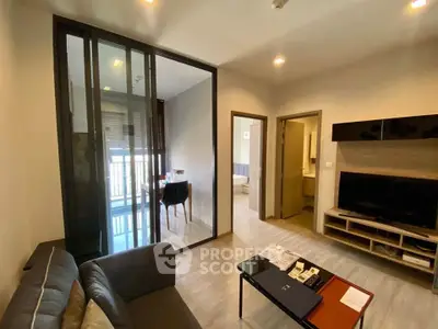 Modern living room with sleek design and glass partition leading to a cozy balcony.