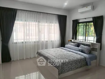 Spacious bedroom with large windows and modern decor