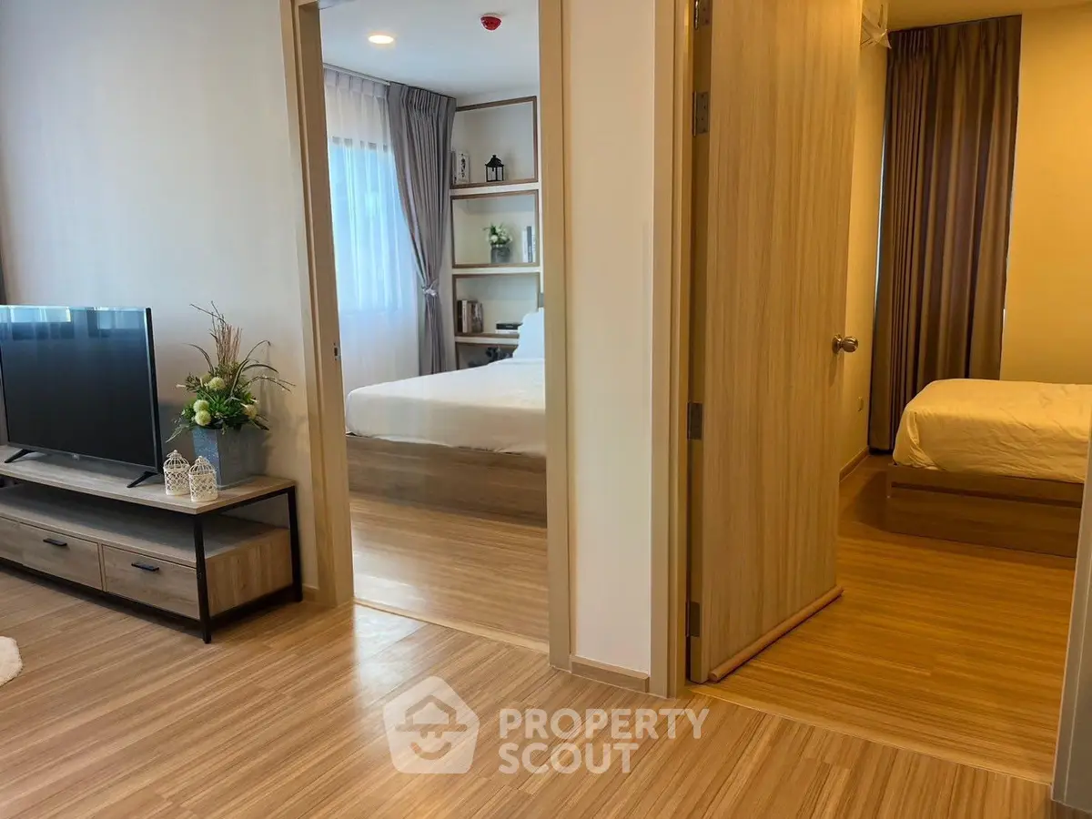 Modern apartment interior with wooden flooring, cozy living room, and two bedrooms.