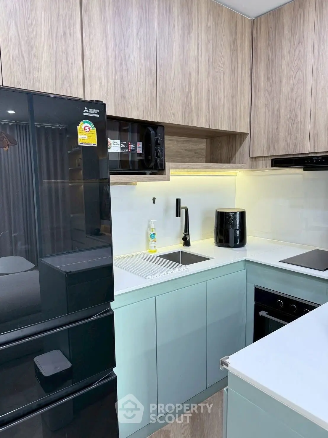 Modern kitchen with sleek cabinetry, black appliances, and under-cabinet lighting.