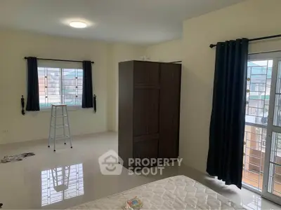 Spacious bedroom with large windows and wardrobe, ideal for natural light lovers.