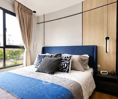 Modern bedroom with stylish decor and large window offering natural light.