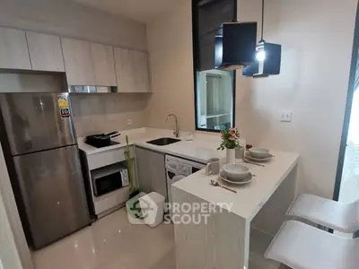 Modern kitchen with sleek appliances and stylish breakfast bar in a contemporary apartment.