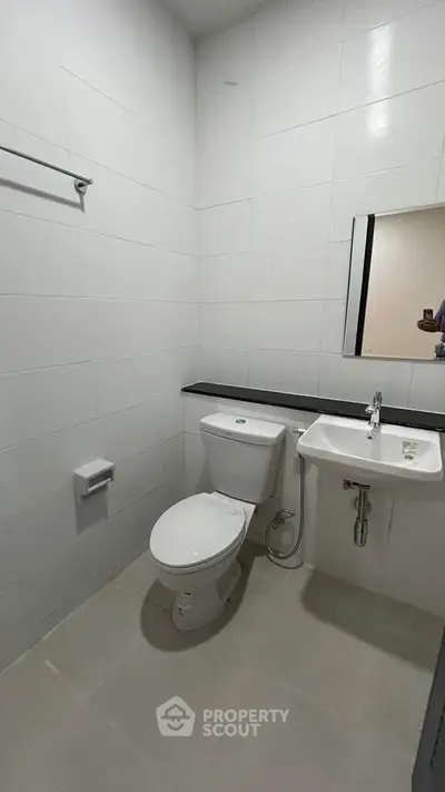 Modern minimalist bathroom with white tiles and sleek fixtures