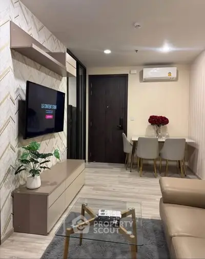 Modern living room with stylish decor and dining area, featuring a wall-mounted TV and air conditioning.