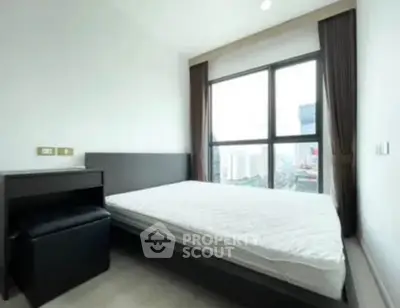 Modern bedroom with large window offering city view, minimalist design, and ample natural light.
