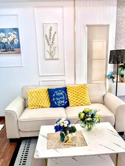 Stylish living room with elegant decor, featuring a cozy sofa, vibrant cushions, and a chic marble coffee table.
