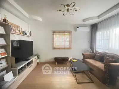 Stylish living room with modern decor, large TV, and cozy seating area.