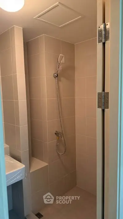 Compact bathroom with modern shower and tiled walls, ideal for efficient space utilization.