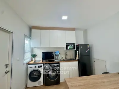 Modern kitchen with washing machine and fridge in compact layout
