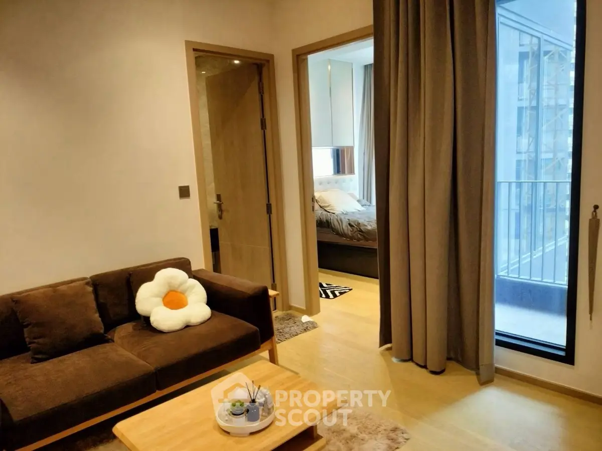 Modern apartment interior with cozy living room and bedroom, featuring a small balcony view.