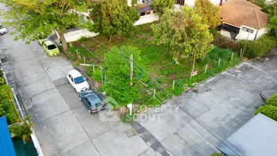 Prime corner lot in residential area with lush greenery and ample parking space.