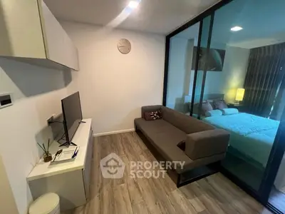 Modern living room with sleek design and glass partition to bedroom