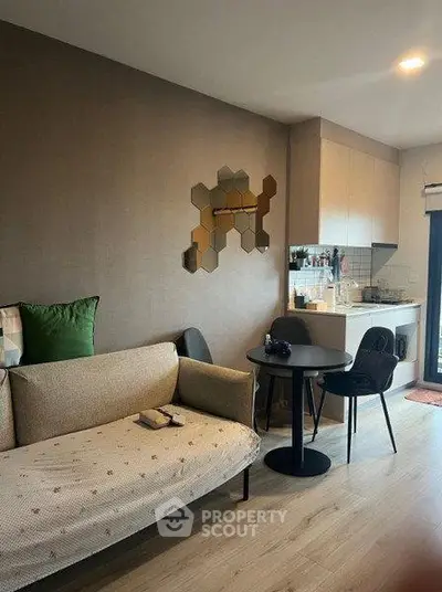 Modern living room with stylish decor and compact kitchen area