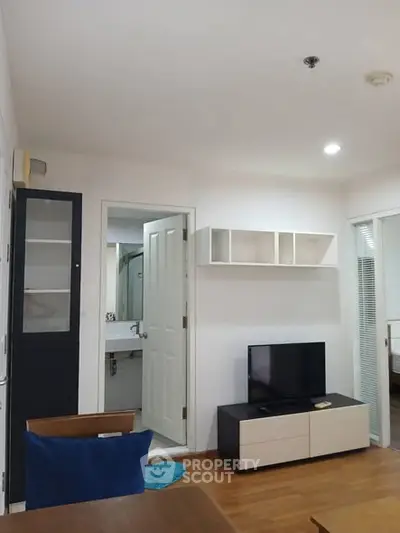 Modern living room with TV and open bathroom view, sleek design