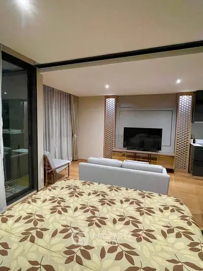 Modern living room with large TV and stylish decor, perfect for relaxation and entertainment.