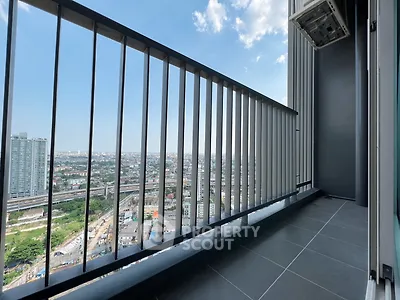 Spacious balcony with panoramic city view in modern high-rise building.