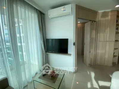 Modern living room with air conditioning and TV, featuring stylish decor and natural light.