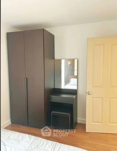 Cozy bedroom with wardrobe and vanity set, perfect for modern living.