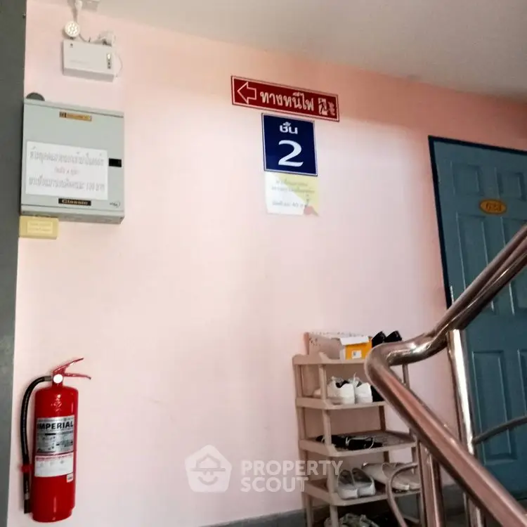 Stairwell in residential building with fire extinguisher and shoe rack