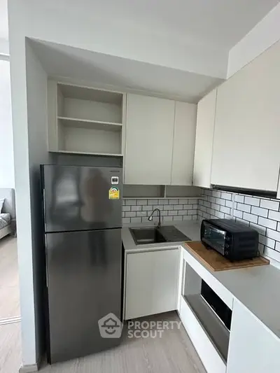 Modern kitchen with sleek appliances and minimalist design in a contemporary apartment.