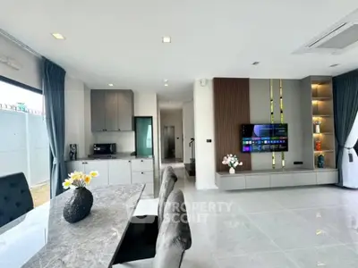 Spacious modern living room seamlessly integrates with a sleek kitchen, featuring high-end appliances, elegant furnishings, and tasteful decor.