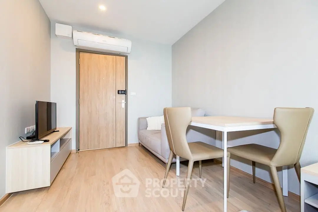Modern living room with sleek furniture and neutral tones, featuring a cozy sofa and dining area.