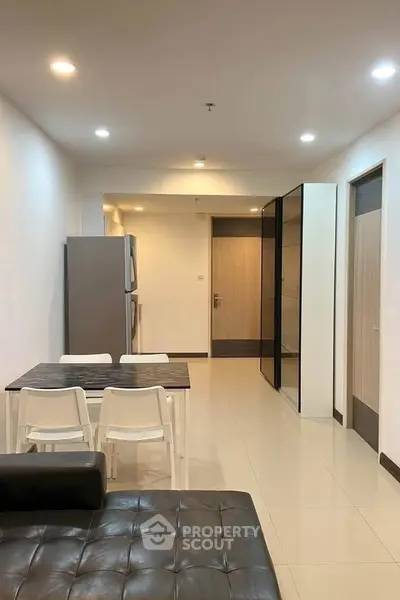 Modern apartment interior with sleek dining area and stylish kitchen appliances.