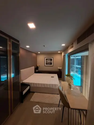Luxurious bedroom with pool view, elegant decor, and modern furnishings in a high-end real estate property.