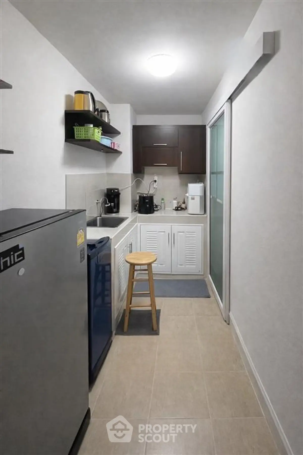 Compact kitchen with modern appliances and sleek cabinetry in a cozy apartment.