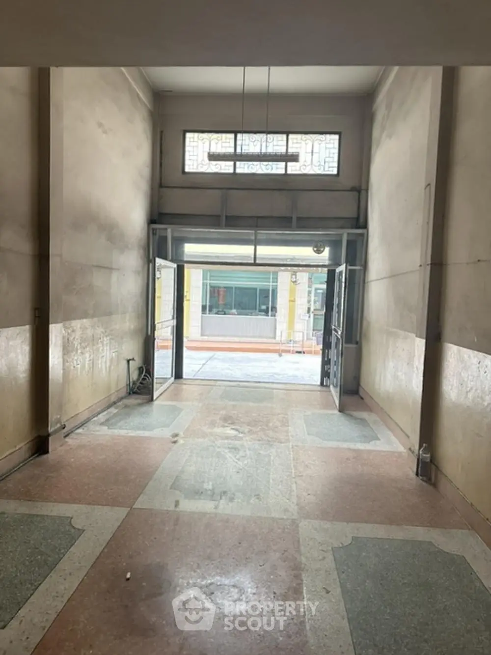 Spacious and well-lit entrance hall with high ceilings, elegant marble flooring, and classic transom windows inviting abundant natural light.