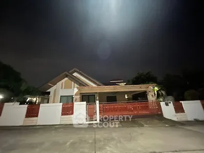 Charming suburban home with red fence and driveway, perfect for family living.