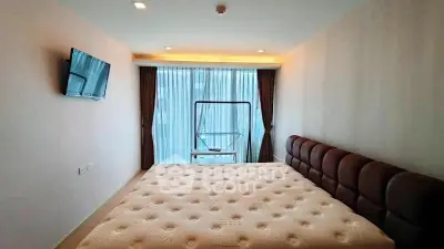 Spacious bedroom with modern decor and large window offering natural light.