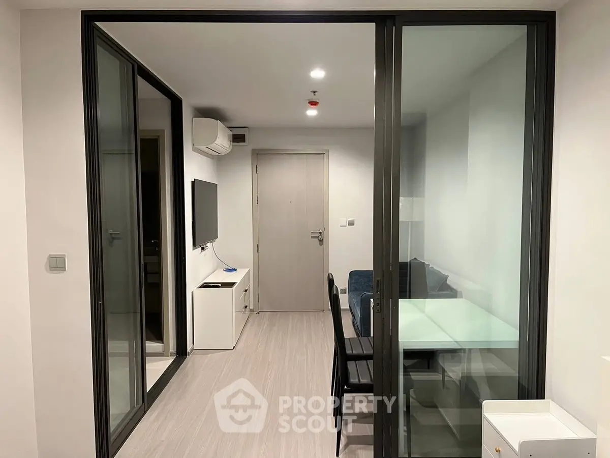 Modern apartment interior with glass partition and sleek furnishings